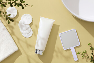 Top view of white cosmetic jar in almond background with sink cotton makeup remover and green leaf for cosmetic advertising 
