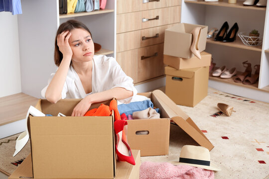 Upset young woman with wardrobe box in dressing room
