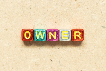 Metallic color alphabet letter block in word owner on wood background