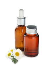 Bottles of chamomile essential oil on white background