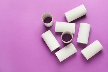Toilet paper cardboard tubes on purple background