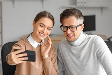 Colleagues taking selfie in office