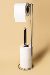 Holder with toilet paper rolls on beige background