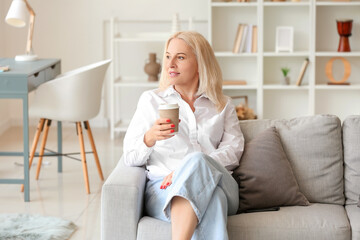 Beautiful mature woman with cup of coffee at home