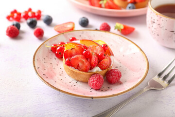 Plate with tasty berry tart on light background