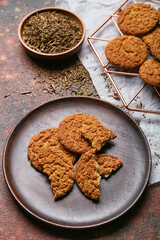 Plate and grid with tasty hojicha cookies on grunge background