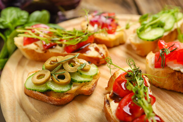 Board with tasty vegetarian bruschettas on table, closeup
