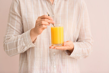 Woman with glass of healthy juice on color background