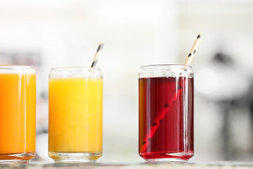 Glasses with healthy juice on table in room, closeup