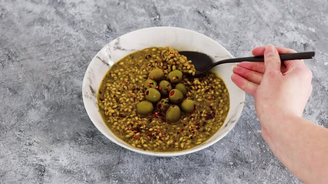 vegan spicy barley with olives and chilli flkes topping, healthy plant-based food