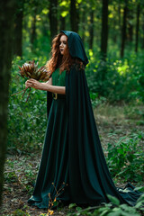 Naklejka premium Young witch in green forest