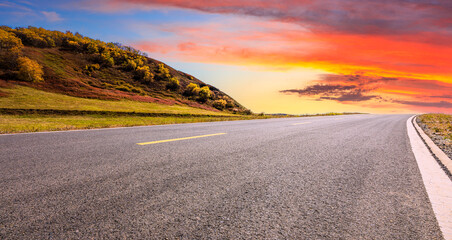 Asphalt road and mountain nature landscape at sunset.Road and mountain scenery in autumn.