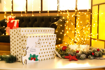 Christmas gifts and decor on table in room