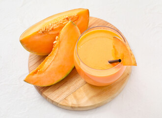 Glass of tasty melon milkshake on white background
