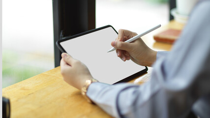 Successful businesswoman using stylus pen to create her presentation on digital tablet