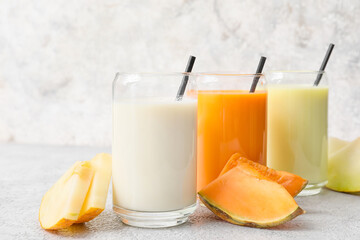 Glasses of tasty melon milkshake on light background, closeup
