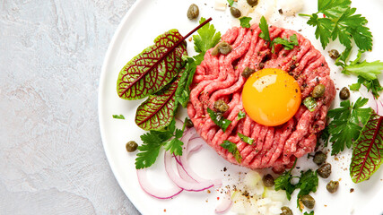 Beef steak tartare on light background. French cuisine concept.