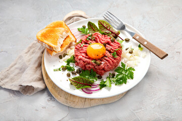 Beef steak tartare on light background. French cuisine concept.