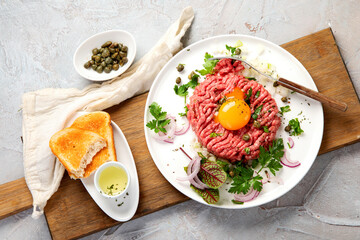 Beef steak tartare on light background. French cuisine concept.