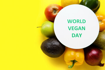 Vegetables, fruits and card with text WORLD VEGAN DAY on color background