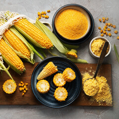 Corncobs and corn groats on gray background.