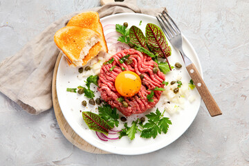 Beef steak tartare on light background. French cuisine concept.