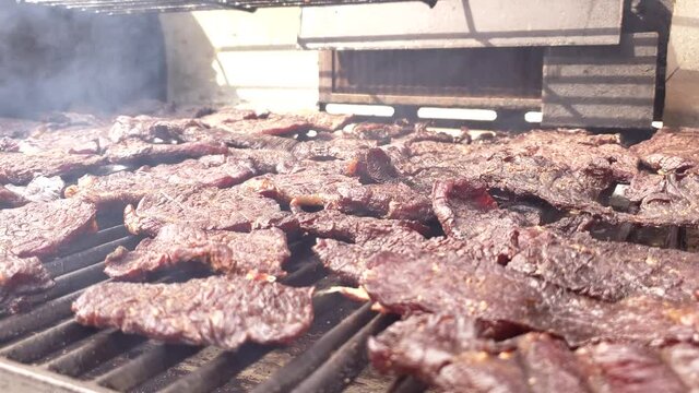 Home Cooking - Close Up Of Meat Slices Being Smoked On Grill Making Beef Jerky.