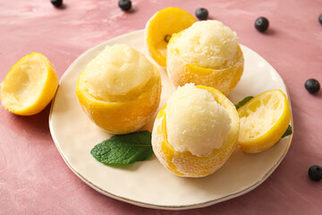 Plate with tasty ice creams in lemon peels on color background