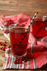 Glass with healthy cranberry juice on wooden background