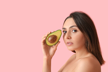 Naked young woman with fresh avocado on color background. Vegan Day