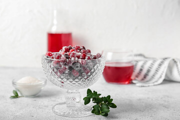 Glass bowl with tasty sugared cranberries on white background