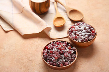 Bowls with tasty sugared cranberries on beige background
