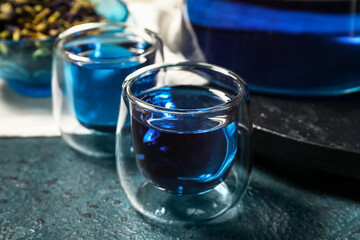 Glass of butterfly pea flower tea on table