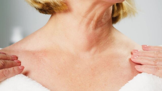 Mature woman touching clavicles close-up, model with smooth healthy skin. Female shoulders, naked body. Beauty and body care concept. Unrecognizable person with bare neck and chest. 