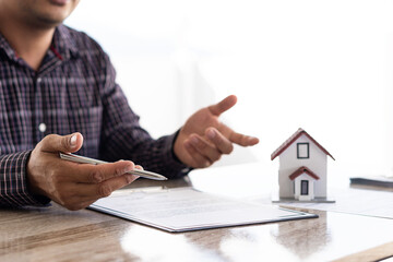 Businessman or home sales representative working in the office with contract documents and...