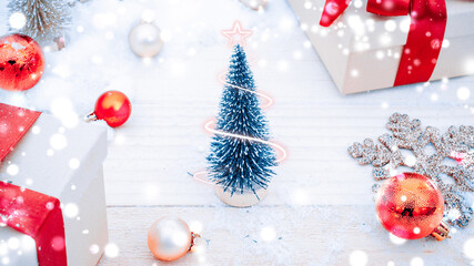 Xmas background table. Winter wooden decoration backdrop. Christmas board with old rustic wall, white frozen snow, golden balls and gift box. New year red bow present.