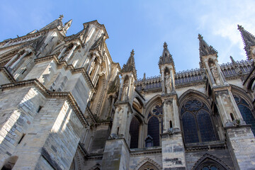 Fototapeta na wymiar Close up view of the ornate medieval Our Lady of Reims Cathedral (Notre-Dame de Reims) in France, with high Gothic architecture, showing its flying buttresses