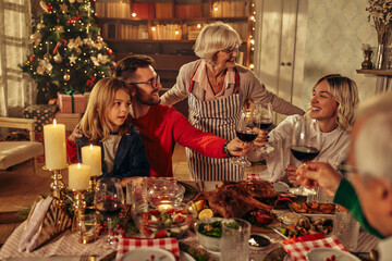 Joyful family celebrating Christmas at dining table.