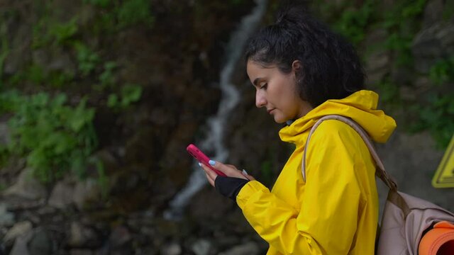 woman is using app with map in smartphone for navigating in natural reserve park