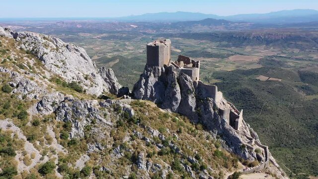 Drone view of ruins of high and isolated medieval defensive Castle de Queribus on stone peak in summer. National heritage site of France