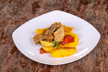 Baked pork meat with potao and tomato