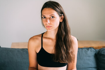 Millennial young pretty woman at home sitting on the couch. Confident and healthy portrait. Long...