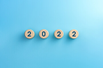Wooden blocks with 2022 icon on blue background
