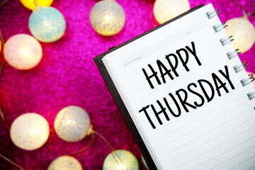 Obraz na płótnie Canvas Happy Thursday text notepad mockup and LED cotton balls decoration on pink bokeh background