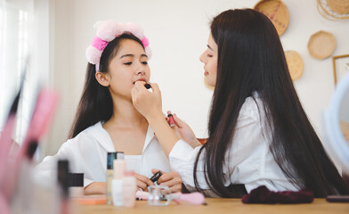 Two beauty bloggers recording makeup tutorial to share on website or social media.