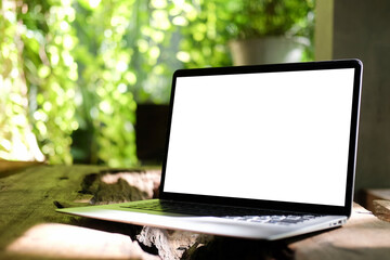 Close up view computer laptop with empty screen on wooden table in the garden.