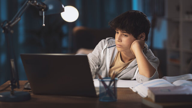 Teenager watching online classes at night