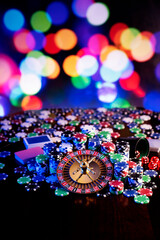 
Casino theme.  Roulette wheel and poker chips on  colorful bokeh background.
