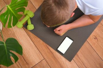 Fototapeta na wymiar Young man working out at home, exercising on a yoga mat, stay fit, plank, active lifestyle. High quality photo