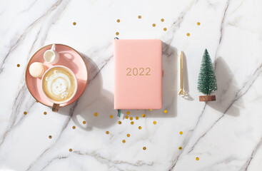 Flat lay composition with New Year's decoration, coral colored 2021 diary book and coffee cup